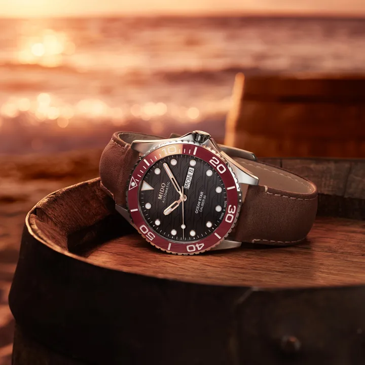 Mido Ocean Star 200C นิยามความงามแห่งท้องฟ้ายามอาทิตย์อัสดง นาฬิกา Mido Ocean Star 200C หน้าปัดสีดำลายคลื่น ขอบเซรามิกสีแดง สายหนังสีน้ำตาล"