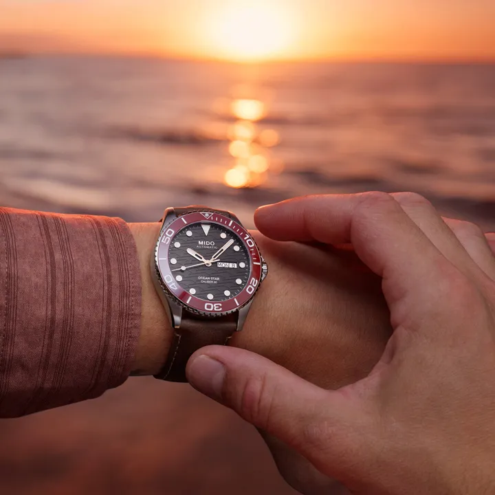 Mido Ocean Star 200C นิยามความงามแห่งท้องฟ้ายามอาทิตย์อัสดง นาฬิกา Mido Ocean Star 200C หน้าปัดสีดำลายคลื่น ขอบเซรามิกสีแดง สายหนังสีน้ำตาล"