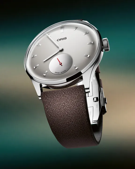 ORIS Hölstein Edition 2026 ความพิเศษบนตัวเรือน Artelier นาฬิกา ORIS Hölstein Edition 2026 หน้าปัดสีเทาพร้อมเข็มวินาทีแยกสีแดงและฝาหลังลาย ORIS Bear เลเซอร์เอฟเฟกต์กระจกเงา