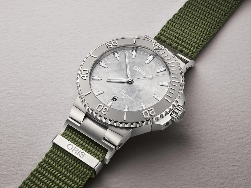 ORIS Social Club Edition II เชื่อม 62 Chapter ทั่วโลกเข้าด้วยกัน นาฬิกา ORIS Social Club Edition II ตัวเรือน 43.5 มม. หน้าปัดสีเงินขัดลาย Frosted พร้อมสาย NATO สีเขียว Olive